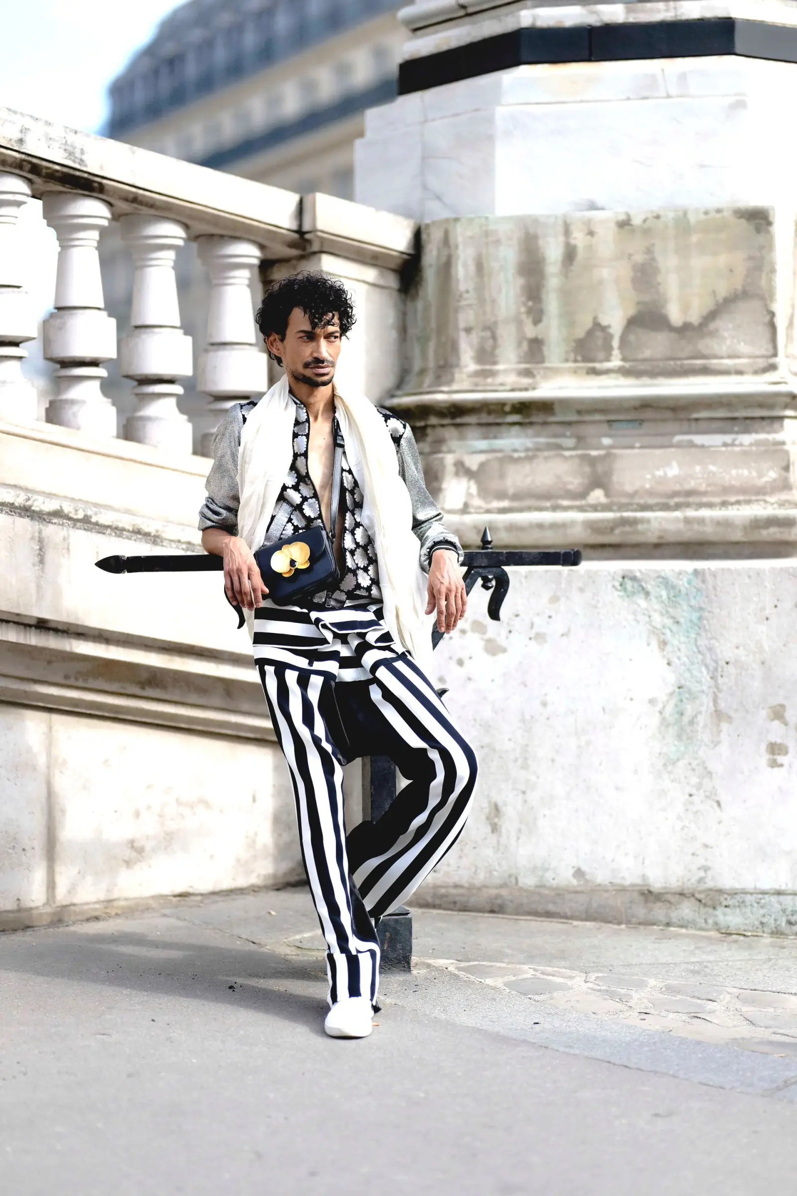 Marlon in a black-and-white striped suit leaning on a Parisian stone balustrade