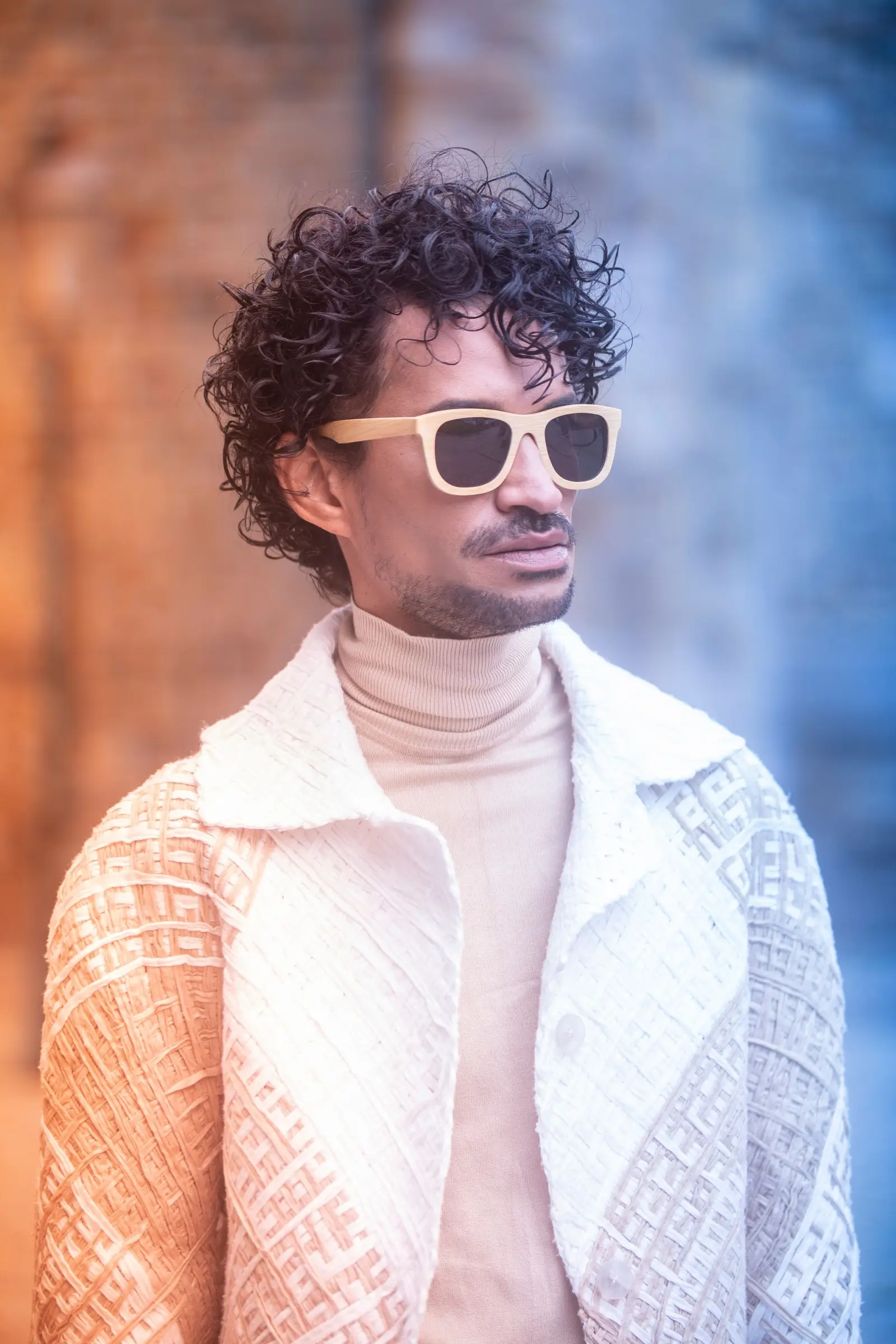 Close-up of Marlon in white sunglasses and a textured ivory jacket