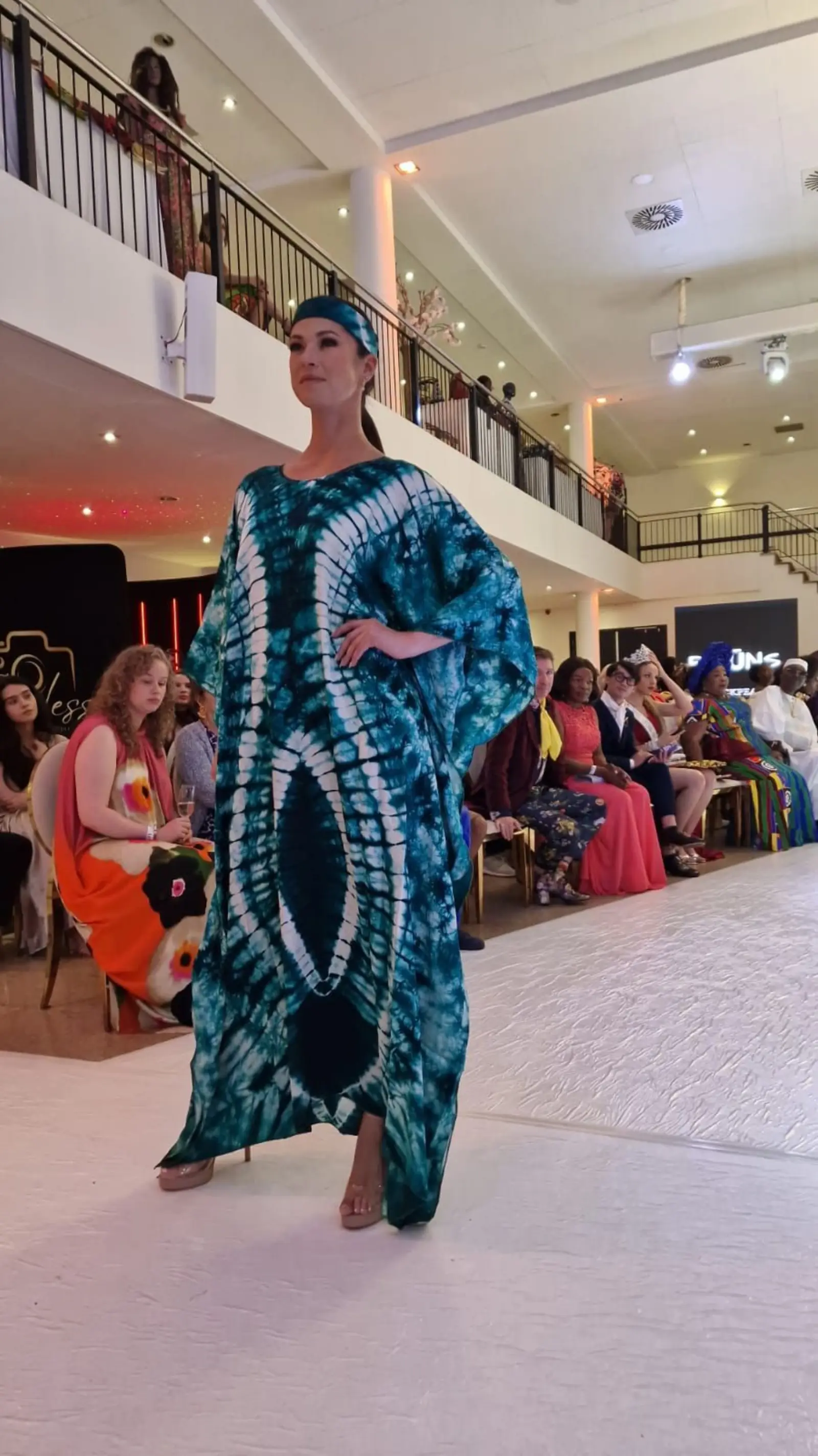 Model in a teal tie-dye kaftan and head wrap